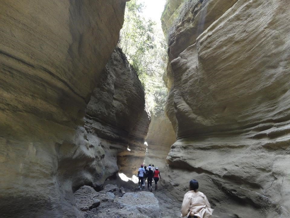 A cyclist riding through the dramatic landscape of Hell's Gate National Park in Kenya.